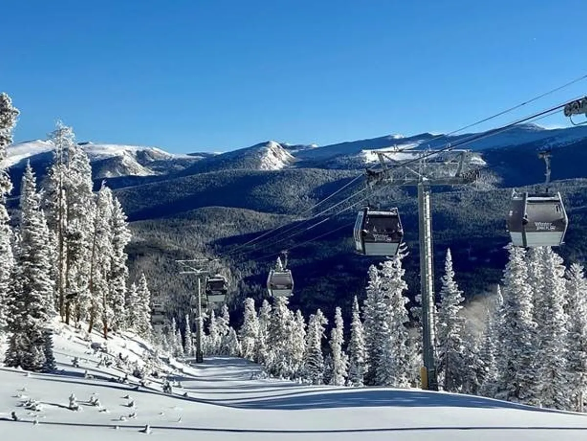An inspiring exterior shot of snow-covered mountains with gondola lifts gliding overhead, capturing the breathtaking views and adventure at Winter Park Resort. The pristine landscape and anticipation in the air set the scene for both exploration and relaxation.