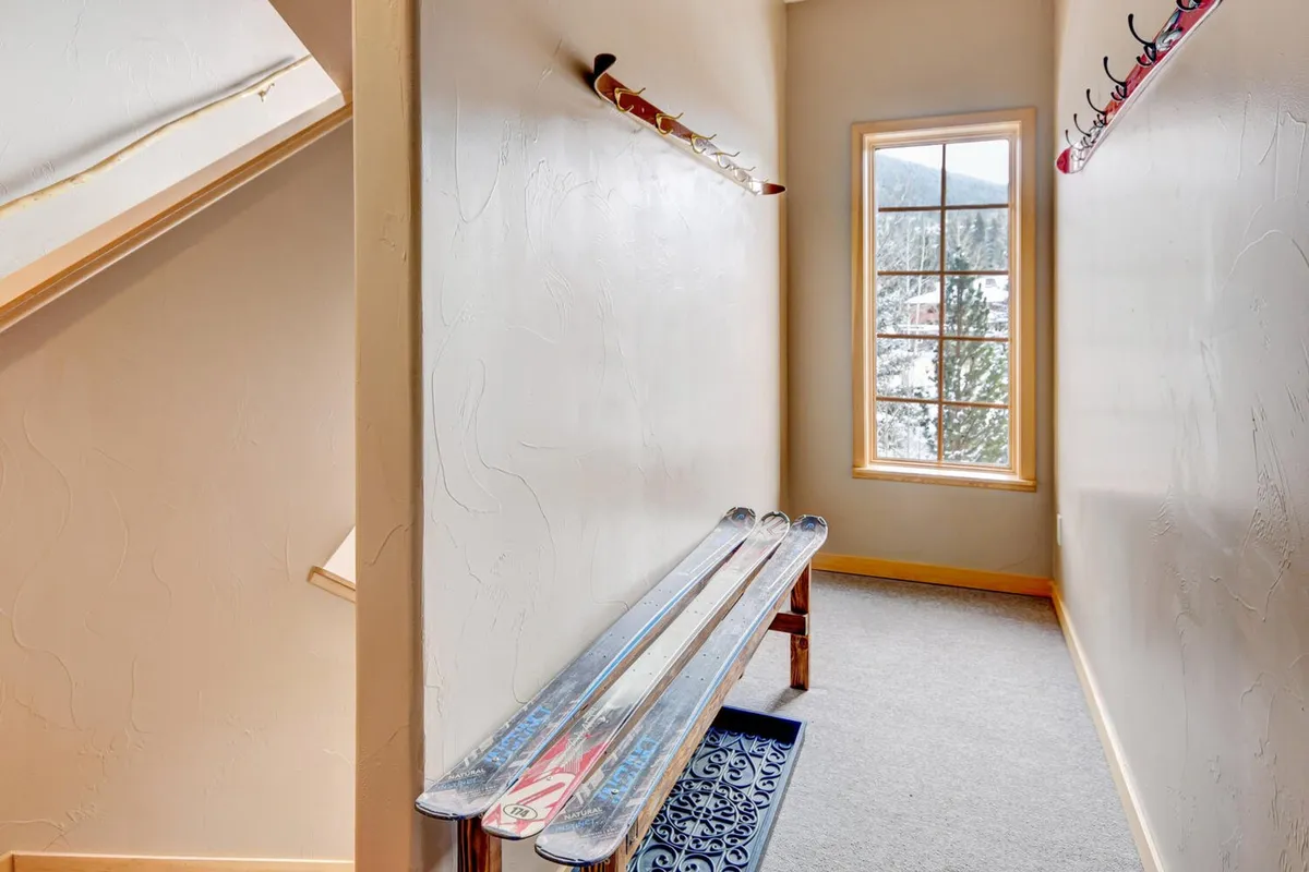 A functional interior entry area with a ski rack, bench, and window, designed for storing gear after outdoor activities. The space is practical and welcoming, making it easy to transition from adventures to relaxation.